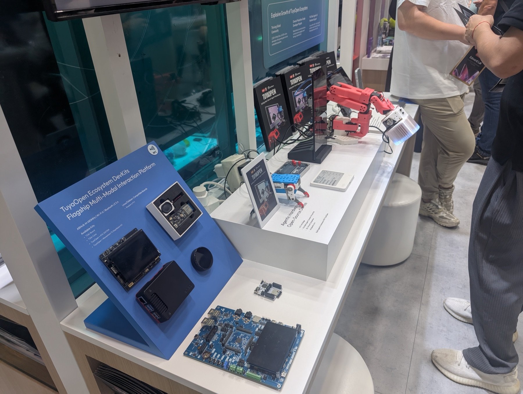 Entwicklerplatinen und ein kleiner roter Roboterarm am Stand von Tuya